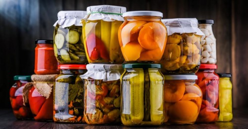 Jars with variety of marinated vegetables and fruits. Preserved food