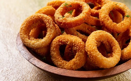 Deep fried onion rings, appetizer, with tomato sauce, on a wooden plate, without people, favorite