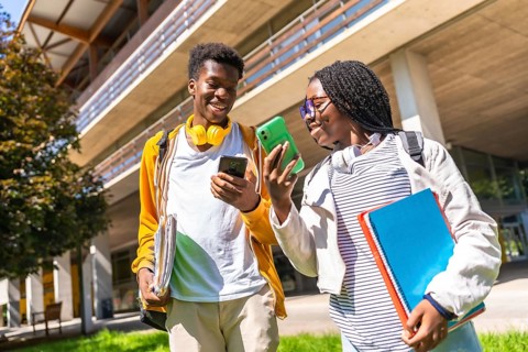 Low angle view photo of male and female african american university friends using phones walking