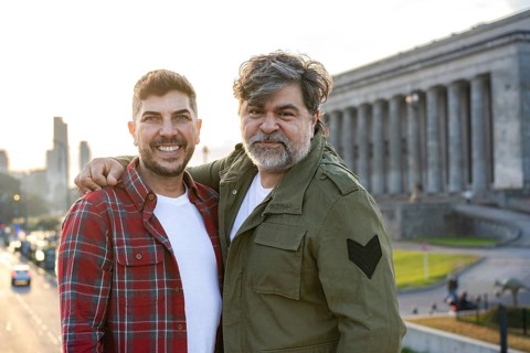 Hispanic gay couple hugging while looking at the camera in Buenos Aires city