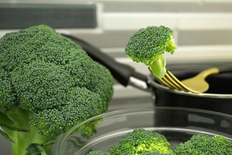 Fresh broccoli on a fork, preparation for cooking on the kitchen table
