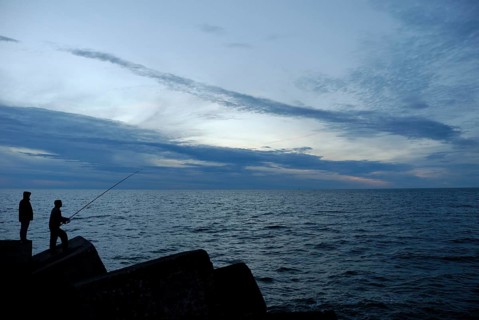 Silhouettes of two people at sunset, Ventspils, Latvia, Europe