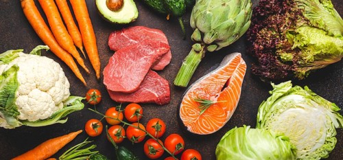 Assorted food raw products: vegetables, beef meat steak, fish salmon fillet on dark rustic brown