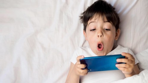 Flat lay kid with phone bed