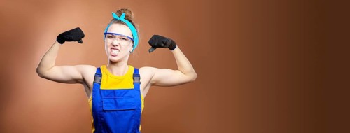 Panoramic beautiful caucasian woman repairman worker with blue eyes in uniform showing arm muscles,