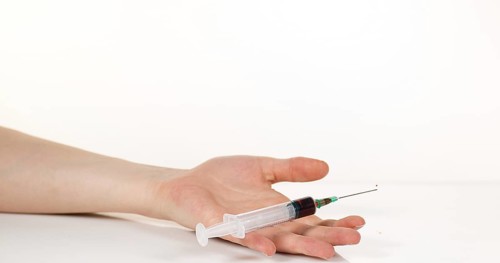 Medical Product Falling into Hand against White Background