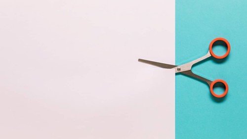 Scissors cutting white paper. High resolution photo