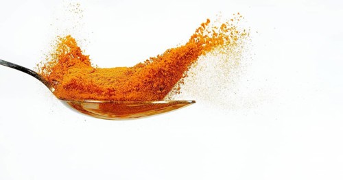 Turmeric (curcuma longa), curcuma Powder falling on Spoon, Indian Spice against white background