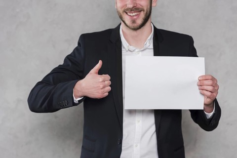 Man giving thumbs up holding blank paper