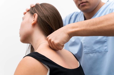 Physiotherapist massaging woman s upper back
