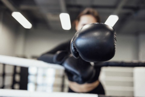 Strong latin boxing woman on the ring at fitness gym. Athletic girl training Muay Thai boxing for