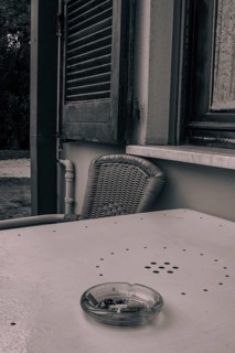 An ashtray with cigarette butts on a table in a monochrome picture, Sirmione, Lake Garda, Italy,