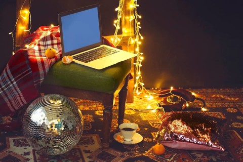 New Year's eve or Christmas still life with retro phone, disco ball, notebook, coffee, candle and
