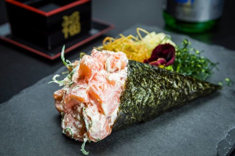 Sushi. Traditional Japanese cuisine, premium salmon Temaki with cream cheese decorated in an