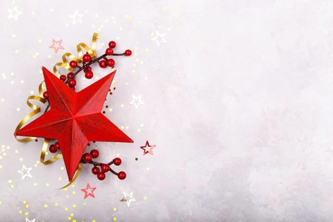 Red star berries Christmas decorations on grey stone background flat lay copy space