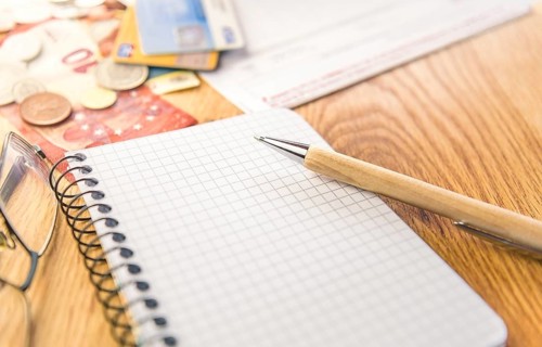 Conceptual image for planing and organizing the financials with a graph notepad, pen, eyeglasses