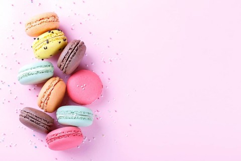 Colorful french macarons on pink background traditioanal desert in France