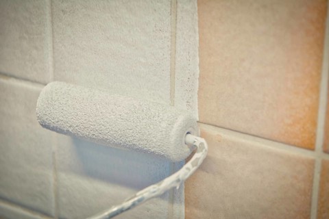 Painting old tiles in the kitchen or bathroom white with a small roller and two component paint.