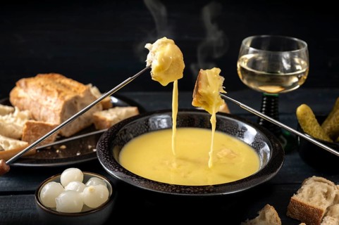 Swiss cheese fondue with bread, pickles and wine, the festive dinner is often served at new year,