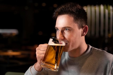 Close up man drinking beer from mug