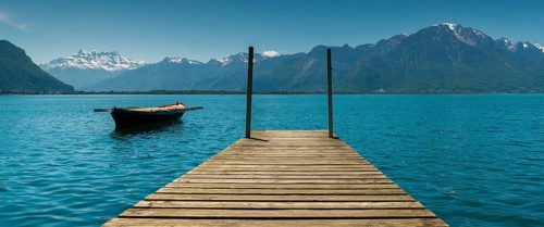 Switzerland - 31 May 2019: mountain and lake landscape with a vintage rescue rowboat and a wooden