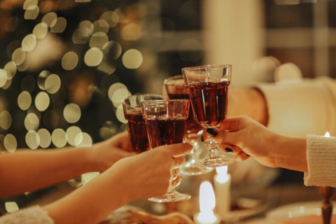 Family friends have fun together in winter eating food on a wooden table. Concept of friendship.