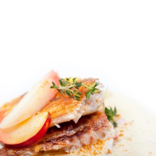 Sea bream orata fillet butter pan fried with fresh peach prune and dragonfruit slices thyme on top,