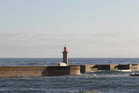 Lighthouse Farolim de Felgueiras in the Atlantic Ocean in the evening light at the beach promenade