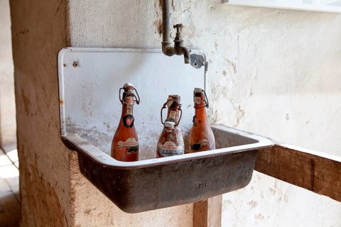 Old beer bottles standing at a washbasin