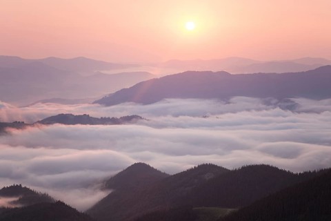 Sunrise over cloudy mountain ridge