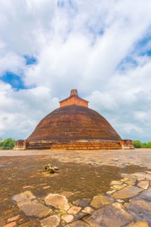 Jetavanaramaya Dagoba or stupa with damaged spire seen centered from platform corner in the ancient