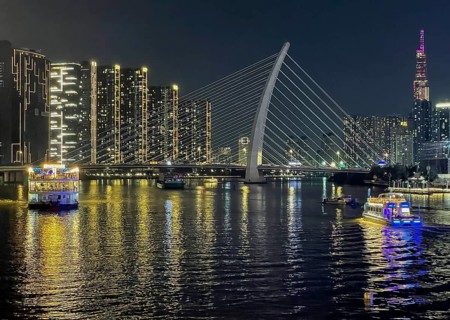 Skyline Saigon, illuminated skyscrapers and bridge Cau Ba Son over the river Song Sai Gon at night,