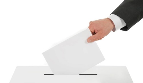 Man's hand down the ballot in the ballot box. Isolated on white
