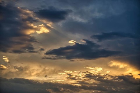 Breathtaking view of a cloudy sky, sun's rays make a gallant attempt to penetrate the thick layer