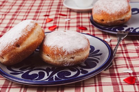 Doughnuts on a plate. The doughnuts are covered with a layer of icing sugar