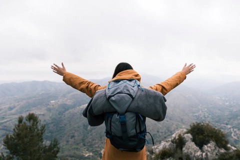 Female backpacker standing top mountain loving nature