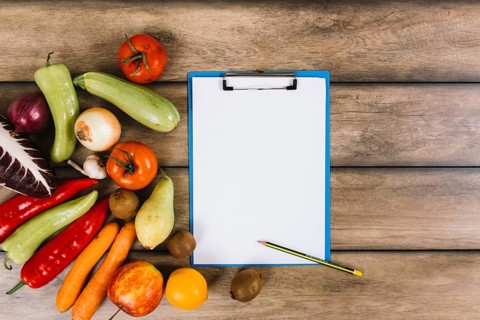 Fruits vegetables near clipboard