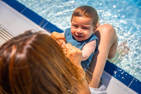 Top view close-up of a caucasian mother with a baby in the lap in the swimming pool
