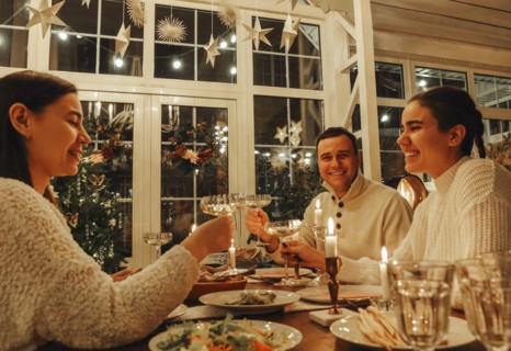 Happy family couple clinking champagne glasses while celebrating New Years Eve or Christmas with