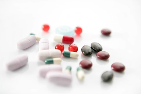 Pills over white, health or suicide, metaphor