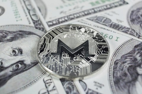 Silver Monero macro photo on hundred dollars bills