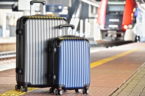 Two plastic travel suitcases on the railroad platform