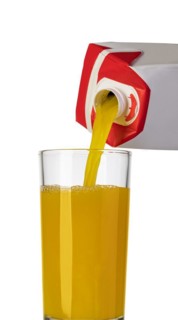 Pouring orange juice from bottle into glass, isolated on white