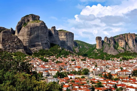 View of Kalampaka and Kastraki villages at foot of Meteora cliffs and pillars on sunny spring day.