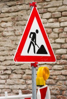 Traffic sign at a construction site with a brickwall in the background