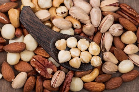 Various organic nuts snack spoon background