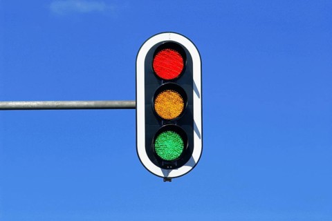 Traffic light in blue sky with red, yellow and green lights on at the same time, blue sky as