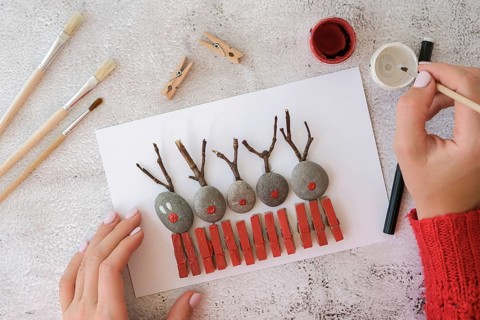 Diy Merry Christmas deer on greeting card postcard made of pebbles, sea stones, clothespins and