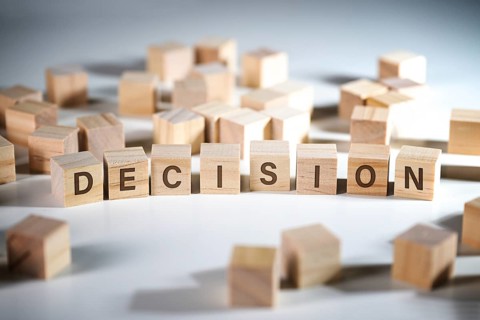 Word DECISION written on wooden cubes among a lot of others, concept to make the right choice in