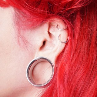 Stretched earlobe piercing with flesh tunnel
